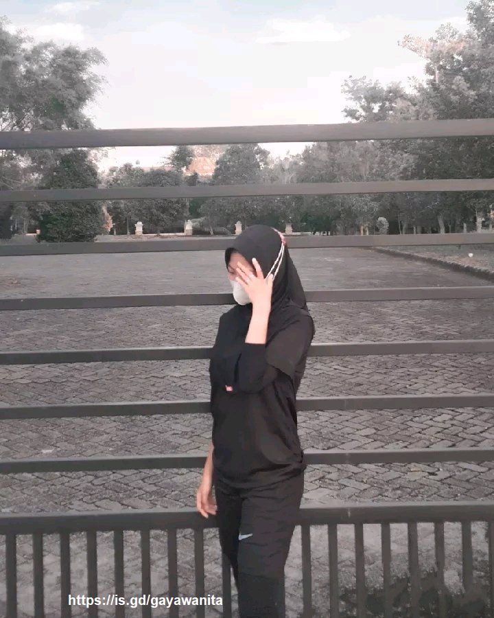 Photo Gaya Gadis Berjilbab Hitam Memakai Masker Sendirian di Taman